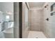 Modern shower with gray tile surround, glass doors, and dark hardware at 203 Arabella Pkwy, Locust Grove, GA 30248