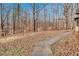 Large, tree-filled backyard with a walking path on a sunny day at 4220 Chapel Hill Farms Dr, Douglasville, GA 30135