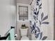 Well-lit bathroom featuring tiled walls, white toilet, and coordinating shower curtain at 4220 Chapel Hill Farms Dr, Douglasville, GA 30135