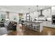 Open-concept living room and kitchen with hardwood floors, modern lighting, and stylish furnishings at 5230 Hyde Rd, Cumming, GA 30040