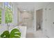 Clean main bathroom with a glass shower, soaking tub, and white tile at 4356 N Buckhead Ne Dr, Atlanta, GA 30342