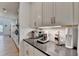 Kitchenette area featuring white cabinetry, under-cabinet lighting, and modern appliances on a sleek, dark countertop at 4391 Encore Blvd, Duluth, GA 30097