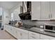 Sleek kitchen featuring white cabinets, stainless steel appliances, and a modern cooktop with a stylish range hood at 4391 Encore Blvd, Duluth, GA 30097