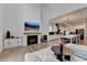 Bright, open-concept living room with hardwood floors, fireplace, view of the kitchen, and modern lighting at 4391 Encore Blvd, Duluth, GA 30097