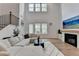 A modern living room featuring a soaring ceiling, large windows, a fireplace, and comfortable seating area at 4391 Encore Blvd, Duluth, GA 30097