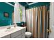 Bathroom features colorful shower curtain, white vanity, and bright blue walls at 1145 Cool Springs Nw Dr, Kennesaw, GA 30144