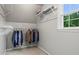Walk-in closet with upper shelves and hanging clothes, illuminated by natural light from a nearby window at 1145 Cool Springs Nw Dr, Kennesaw, GA 30144