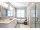 Elegant bathroom featuring a soaking tub, double vanity with marble countertop, and frameless glass shower at 3042 Jefferson St, Atlanta, GA 30341