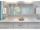 Bathroom vanity with double sinks, white cabinets, quartz countertop, and framed mirror reflecting the glass shower at 3042 Jefferson St, Atlanta, GA 30341