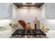 Close-up of the kitchen showcasing the gas cooktop, white subway tile backsplash, and open shelving at 3042 Jefferson St, Atlanta, GA 30341