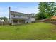 Large, grassy backyard with a wooden fence, beautiful landscaping, and covered patio at 406 Mount Vernon Ct, Woodstock, GA 30189