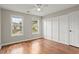 Bright bedroom with hardwood floors, neutral walls, and two windows offering neighborhood views at 406 Mount Vernon Ct, Woodstock, GA 30189