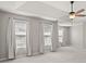 Bright bedroom featuring three windows, a ceiling fan, and neutral-toned walls, offering a serene and airy atmosphere at 406 Mount Vernon Ct, Woodstock, GA 30189