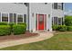 Close-up of home's entrance, featuring a vibrant red door and manicured bushes at 406 Mount Vernon Ct, Woodstock, GA 30189