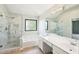 Bright bathroom featuring a glass shower, soaking tub, double sinks and a large vanity mirror at 1745 Fairburn Dr, Cumming, GA 30040