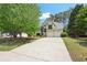 Spacious home featuring a long driveway, attached two-car garage, and a beautifully maintained lawn and landscaping at 1745 Fairburn Dr, Cumming, GA 30040