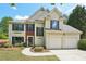 Charming two-story home with a two-car garage, complemented by lush greenery and a well-manicured lawn at 1745 Fairburn Dr, Cumming, GA 30040