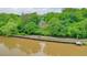 Aerial view of a home with a river in the foreground and lush green trees at 305 High Branch Way, Roswell, GA 30075