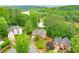 Aerial view of stately brick homes nestled in a lush, green, wooded neighborhood at 305 High Branch Way, Roswell, GA 30075