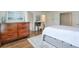 Bright bedroom featuring wood floors, a wooden dresser, a patterned rug, and a dedicated desk space at 305 High Branch Way, Roswell, GA 30075