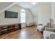 Relaxing bonus room featuring hardwood floors, neutral walls, and comfortable seating under a vaulted ceiling at 305 High Branch Way, Roswell, GA 30075