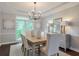 Formal dining room with elegant decor, a chandelier, and large windows overlooking the yard at 305 High Branch Way, Roswell, GA 30075