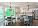 Eat-in kitchen with stainless appliances, tile backsplash, and island seating, offering a seamless dining experience at 305 High Branch Way, Roswell, GA 30075