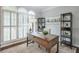 Bright home office with large windows, shutters, a wooden desk, and built-in shelving at 305 High Branch Way, Roswell, GA 30075