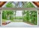 Scenic covered patio with seating overlooking a serene, lush backyard and water views at 305 High Branch Way, Roswell, GA 30075