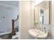 Stylish powder room with elegant mirror, pedestal sink, and modern fixtures, maximizing space and design at 305 High Branch Way, Roswell, GA 30075