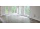Sunroom with multiple windows overlooking a green yard with neutral vinyl floors at 305 High Branch Way, Roswell, GA 30075