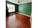 A spacious bedroom with rich hardwood flooring and a bright window with green walls at 4832 Batiste Nw Ln, Acworth, GA 30101