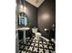 Chic half bathroom with black walls, patterned tile floors, and a pedestal sink for a modern aesthetic at 4832 Batiste Nw Ln, Acworth, GA 30101