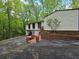 Home exterior featuring a garage and brick landscaping surrounded by lush greenery at 1720 Valley Ln, Cumming, GA 30040