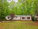 Cozy home exterior featuring well-maintained lawn and mature trees, offering a serene and private setting at 1720 Valley Ln, Cumming, GA 30040