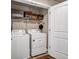 Laundry room with modern washer and dryer, shelving, and storage baskets for organized convenience at 255 Skipjack Ct, Covington, GA 30016
