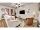 Bright living room featuring hardwood floors, comfortable seating, and stylish gold and glass side tables at 255 Skipjack Ct, Covington, GA 30016