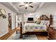 Spacious main bedroom featuring hardwood floors, tray ceilings, and a luxurious, ornate wood bed frame at 255 Skipjack Ct, Covington, GA 30016