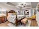 Large main bedroom featuring tray ceilings, a wood bed frame, stylish decor, and hardwood floors at 255 Skipjack Ct, Covington, GA 30016