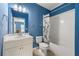 Modern bathroom with a tub-shower combo, white cabinets and blue walls at 3810 Sweat Creek Run, Marietta, GA 30062