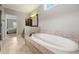 Soaking tub with tile surround and a window for natural light at 3810 Sweat Creek Run, Marietta, GA 30062