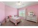Cozy bedroom with pink walls, carpet, ceiling fan, and a bed with patterned bedding at 3810 Sweat Creek Run, Marietta, GA 30062