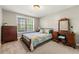 Comfortable bedroom with natural light, furnished with a cozy bed, dresser, and vintage-style vanity at 3810 Sweat Creek Run, Marietta, GA 30062
