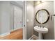 Chic powder room with pedestal sink, round mirror, and neutral paint scheme at 3810 Sweat Creek Run, Marietta, GA 30062