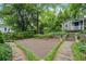 Landscaped backyard featuring a detached guesthouse with stone steps, a stone wall and a gravel area at 25 Standish Nw Ave, Atlanta, GA 30309