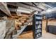 Unfinished basement with stairs and storage shelves, revealing the home's foundation at 25 Standish Nw Ave, Atlanta, GA 30309