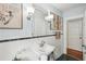 This bathroom has white tiling, blue walls, vanity with a mirror and sconces, and an open doorway to another room at 25 Standish Nw Ave, Atlanta, GA 30309