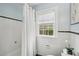 This bathroom offers white tiling with a contrasting black border, a window, and a shower with a curtain at 25 Standish Nw Ave, Atlanta, GA 30309