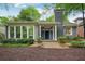 Gray brick home exterior featuring a welcoming front porch with blue door and well-maintained landscaping at 25 Standish Nw Ave, Atlanta, GA 30309