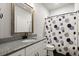 Bathroom featuring a granite countertop, white cabinets, and a shower-tub combination at 3668 Spring St, Chamblee, GA 30341